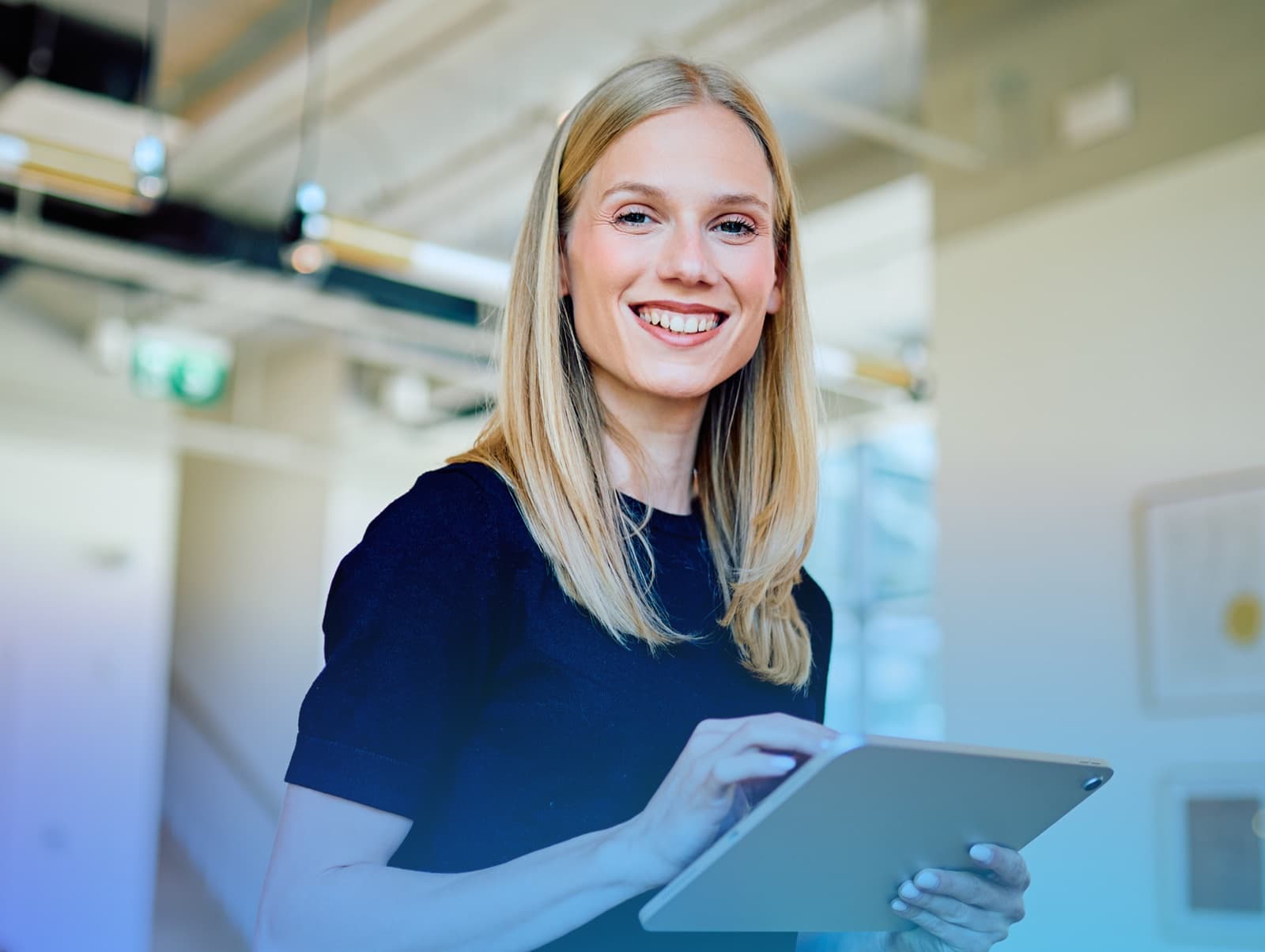 Team member smiling while reviewing content on a tablet